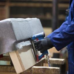 Trabajador ensamblando componentes automotrices en taller especializado.