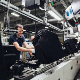 Trabajador en línea de ensamblaje automotriz en fábrica moderna.